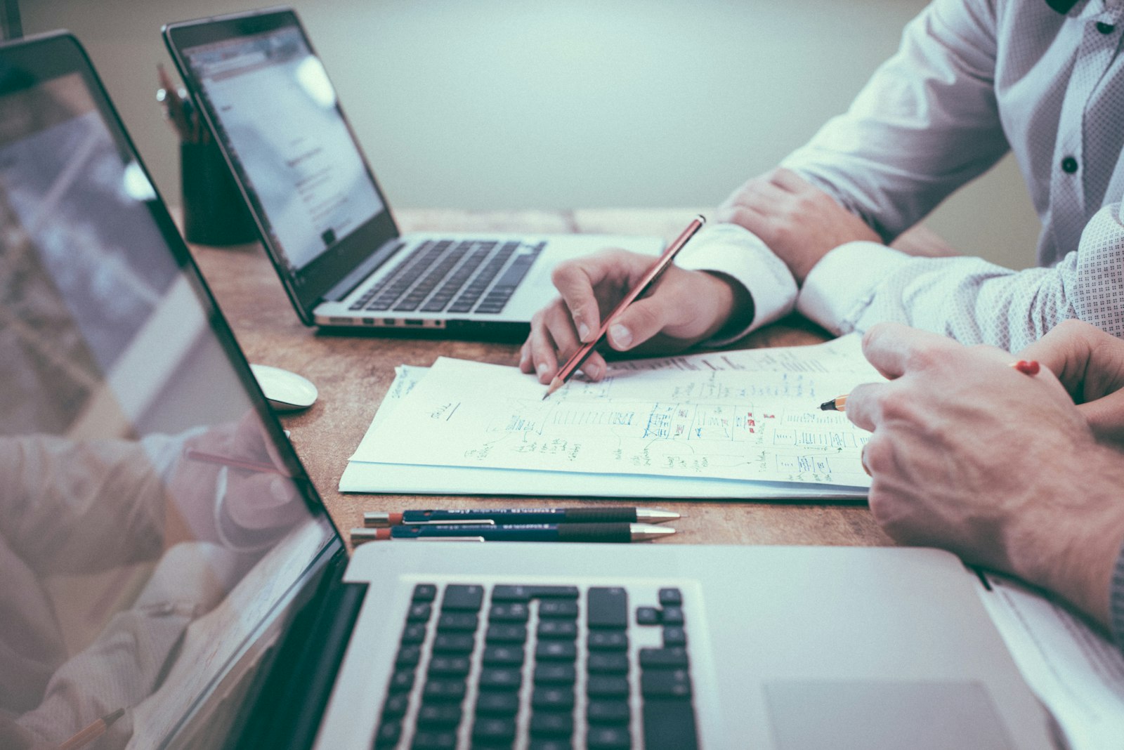 Business professional reviewing financial documents and a laptop at an office desk
