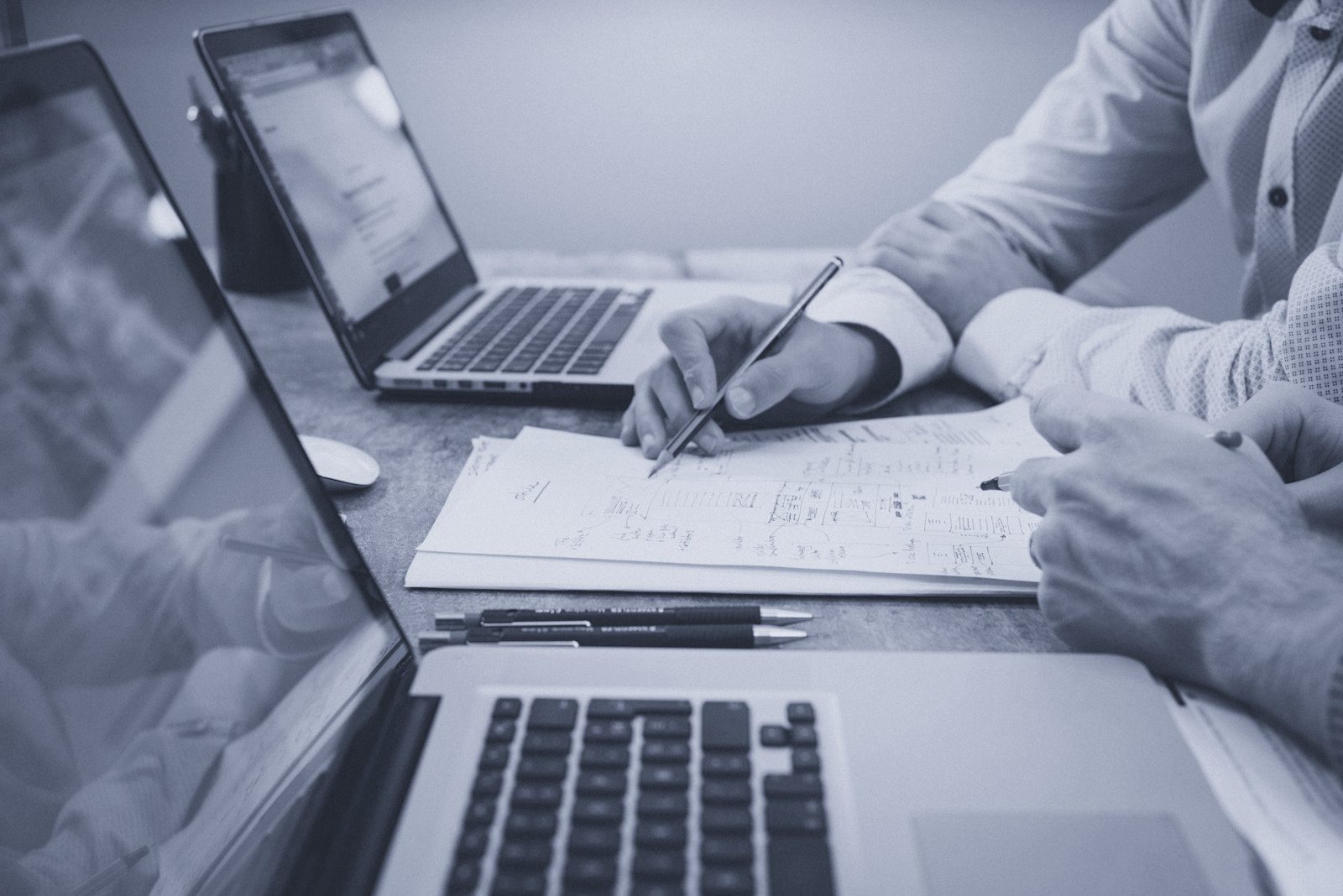 Financial professional reviewing deal documents and spreadsheets at a desk